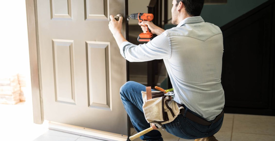 Young man fixing a door lock